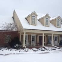 Front porch gutters on a home with three dormers after a snowfall